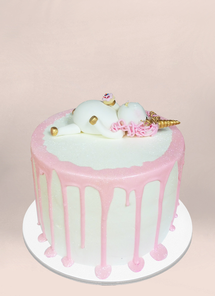 Photo: unicorn laying on back with a donut icing cake