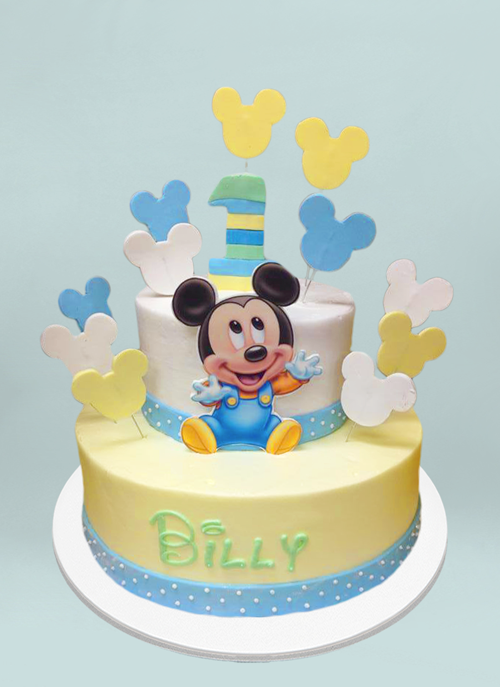 Photo: baby mickey on 2 tier cake with disney writing