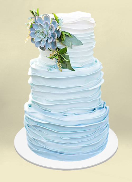 Photo: frosted 3 tiers ombre color white to sky blue and blue succulent and leaves on top tier