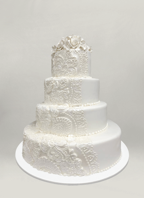 Photo: white cake with intricate piping pattern and sugar flowers