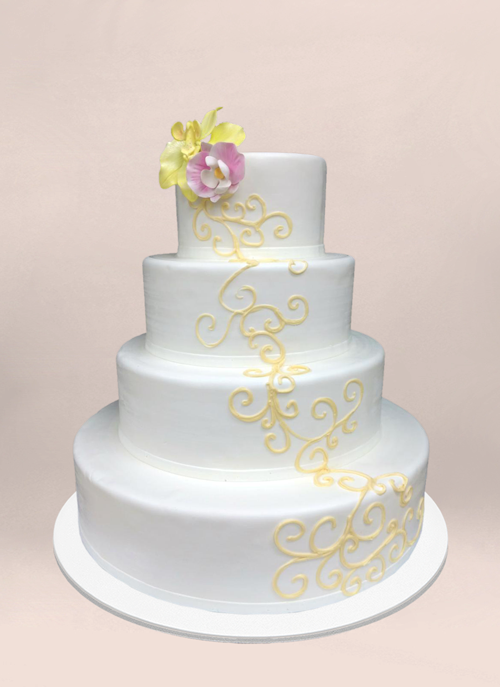 Photo: smooth white cake with yellow cascading scroll pattern and fondant flowers