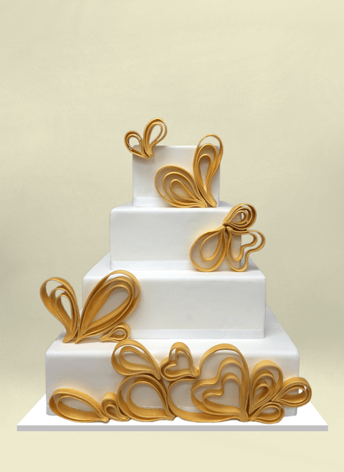 Photo: four white sqaure tiers with dimensional gold ribbon hearts