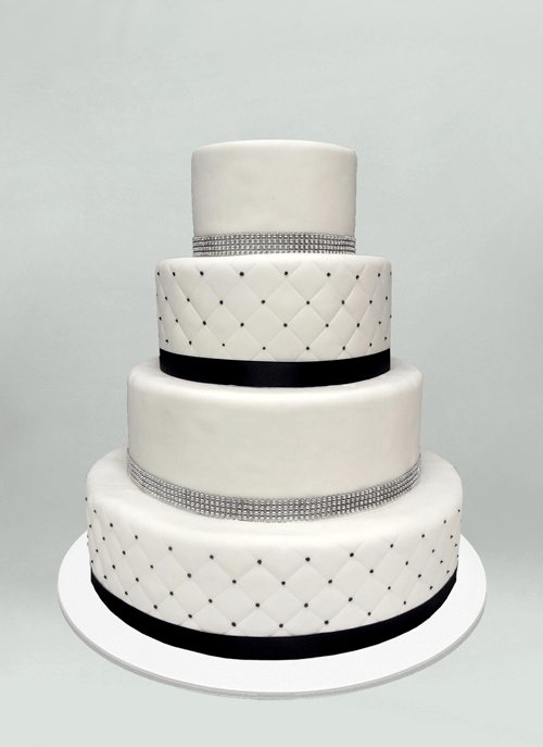Photo: white fondant cake with cushion pattern and navy or gem ribbon